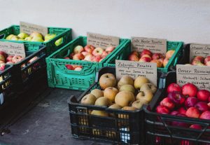 Unterschiedliche Äpfel in Kisten mit Herkunftsschild