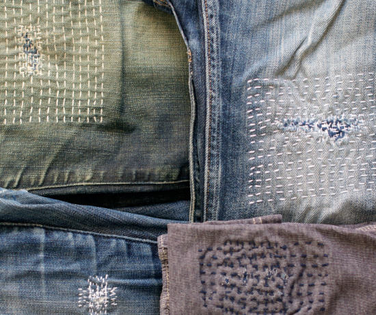 Vier geflickte Jeans-Hosen in unterschiedlichen Farben