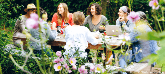 Menschen im Garten an einem Tisch