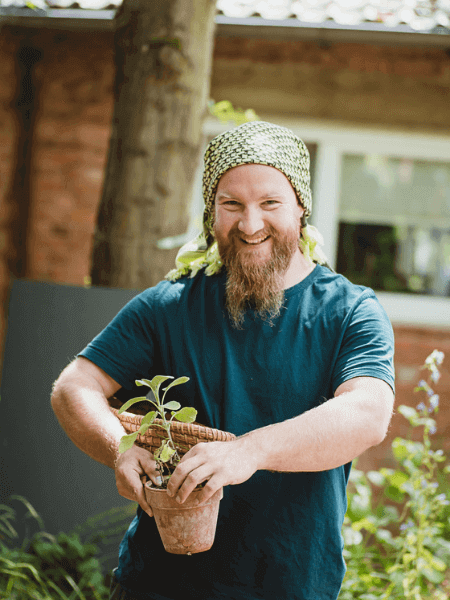 Jonas Gampe mit Blumen in der Hand im Garten