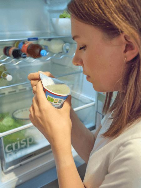 Frau riecht an Joghurt