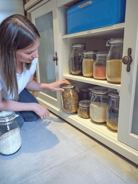 Frau holt Vorräte aus dem Schrank