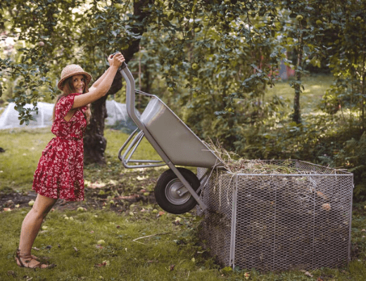 Frau kippt Gartenabfälle in Kompostbehälter