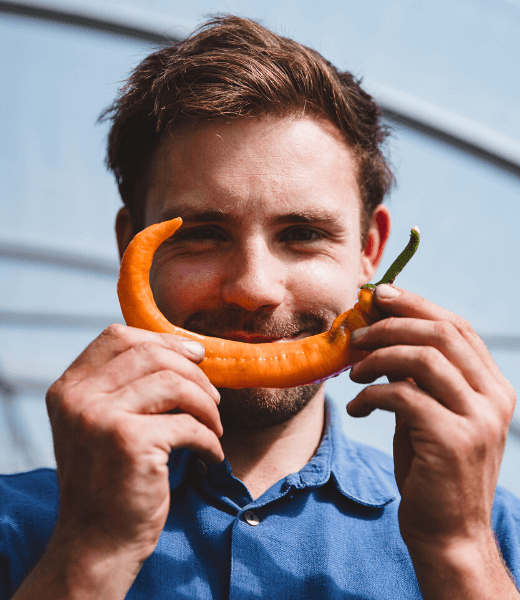 Mann mit Paprika vor dem Mund