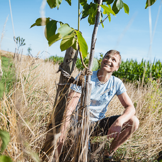 zwei Männer mit Baum am Acker